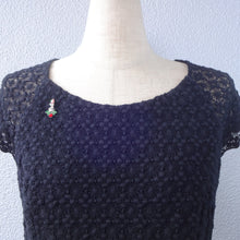 画像をギャラリービューアに読み込む, ヒイラギの上に置かれたろうそくをイメージしたビジューバッジ