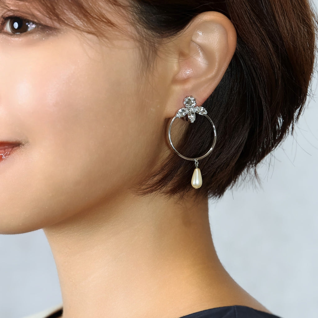 パールとラインストーンのイヤリングを着けた女性